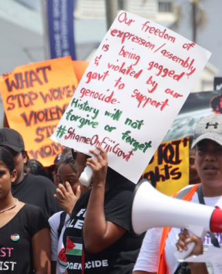 An "Our freedom of expression/assembly is being gagged and violated by our government to support genocide" placard