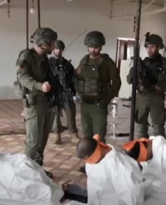 This screenshot from a video broadcast on Israeli channel Now 14 shows an officer and four soldiers of Israel’s Givati Brigade standing next to Palestinian detainees