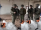 This screenshot from a video broadcast on Israeli channel Now 14 shows an officer and four soldiers of Israel’s Givati Brigade standing next to Palestinian detainees