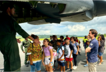 A group of schoolchildren boarding a military aircraft