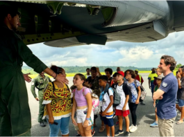 A group of schoolchildren boarding a military aircraft