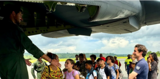 A group of schoolchildren boarding a military aircraft