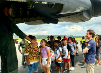 A group of schoolchildren boarding a military aircraft