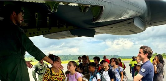 A group of schoolchildren boarding a military aircraft