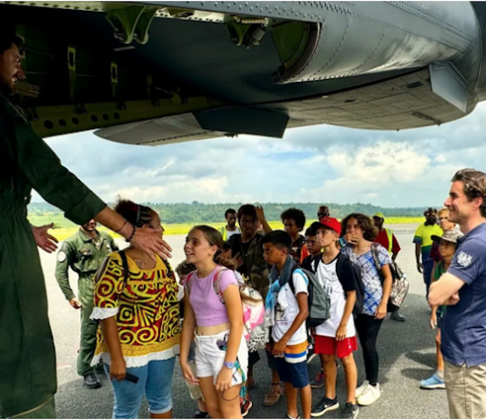 A group of schoolchildren boarding a military aircraft