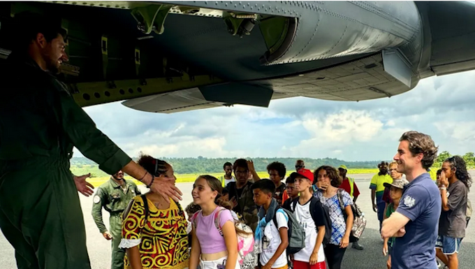 A group of schoolchildren boarding a military aircraft