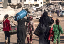 Displaced Palestinians walk through the destruction in Rafah in southern Gaza