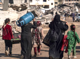 Displaced Palestinians walk through the destruction in Rafah in southern Gaza