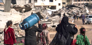 Displaced Palestinians walk through the destruction in Rafah in southern Gaza