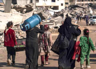 Displaced Palestinians walk through the destruction in Rafah in southern Gaza
