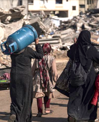 Displaced Palestinians walk through the destruction in Rafah in southern Gaza