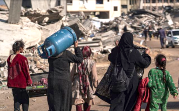 Displaced Palestinians walk through the destruction in Rafah in southern Gaza