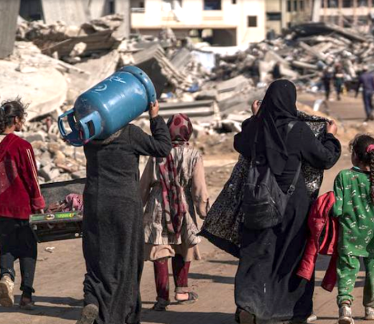 Displaced Palestinians walk through the destruction in Rafah in southern Gaza