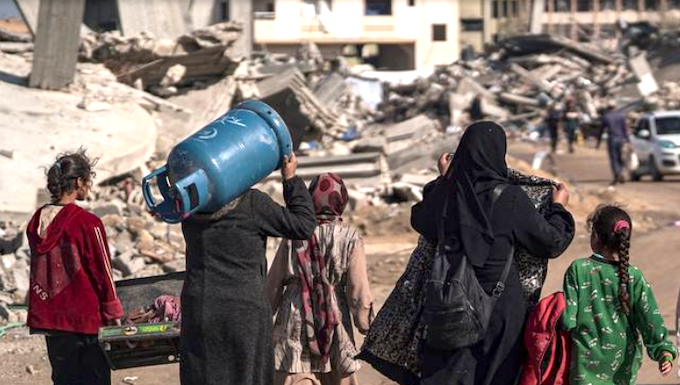 Displaced Palestinians walk through the destruction in Rafah in southern Gaza