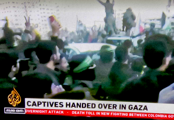 Armed Hamas fighters escort the Israeli captives