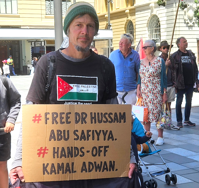 Protester Jason holds a placard calling for Kamal Adwan Hospital medical director Dr Hussam Abu Safiyyan to be set free