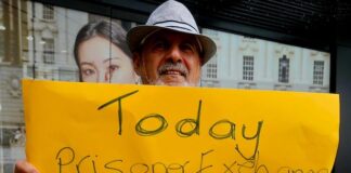 A protester for Palestine holds up a poster in Te Komititanga Square