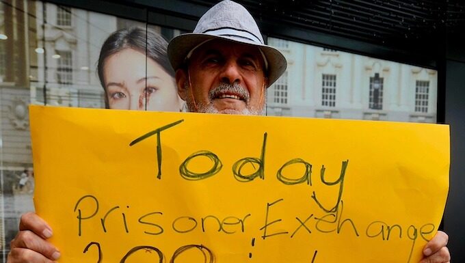 A protester for Palestine holds up a poster in Te Komititanga Square