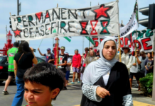 Cheerleader Ali Gouda leads the Palestine genocide protesters into Te Komititanga Square during the "march of the martyrs"