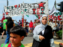 Cheerleader Ali Gouda leads the Palestine genocide protesters into Te Komititanga Square during the "march of the martyrs"