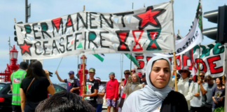 Cheerleader Ali Gouda leads the Palestine genocide protesters into Te Komititanga Square during the "march of the martyrs"