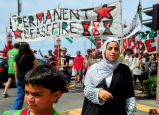 Cheerleader Ali Gouda leads the Palestine genocide protesters into Te Komititanga Square during the "march of the martyrs"