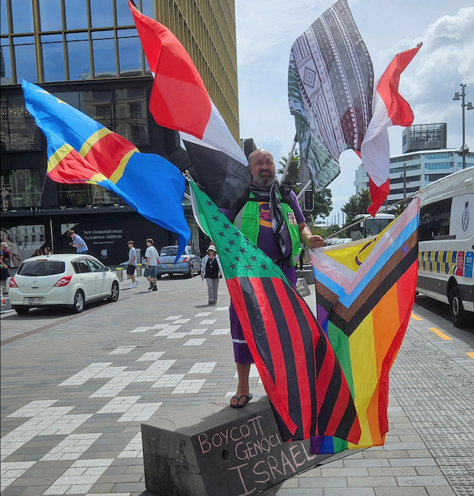 Samoan artist Michel Mulipola with his characteristic clutch of protest flags