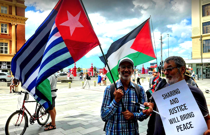 Two of the pro-Palestine protesters hold West Papuan and Palestinian flags 