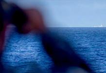 A crew member on board the RAN frigate HMAS Stuart monitors the Chinese Navy's missile destroyer Zunyi and the supply ship Weishanhu