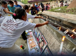 Families and survivors hold a symbolic offering of flowers and lighting of candles