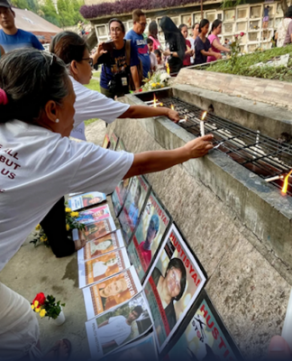 Families and survivors hold a symbolic offering of flowers and lighting of candles