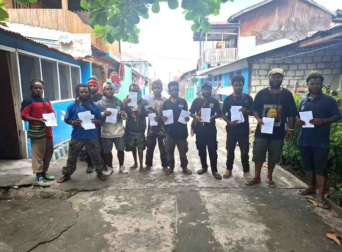 The arrested Sentani 12 activists holding leaflets for the Boycott for West Papua campaign