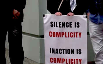 "Silence is complicity" . . . a placard on a sign at the protest outside the Israeli Embassy in Wellington today