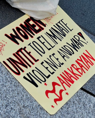 A Filipino "Women unite to eliminate violence and war" placard