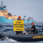 Greenpeace International activists display a banner in front of the Maersk Launcher