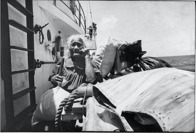 An elderly Rongelap woman on board the Rainbow Warrior with her "home" and possessions
