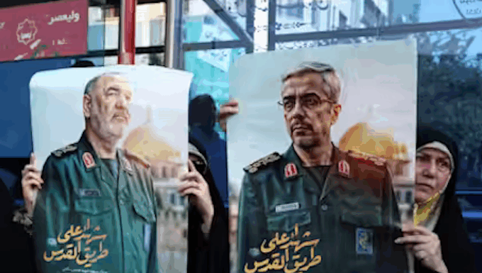Iranians hold posters of late Islamic Revolutionary Guard Corps head Hossein Salami (left), and late Iranian Armed Forces Chief of Staff General Mohammad Bagheri (right), who were killed in Israeli airstrikes in recent days