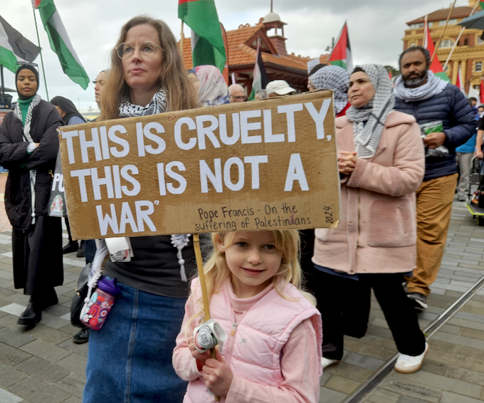 "This is cruelty - this is not a war," says this young girl's placard quoting the Pope