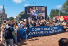 A West Papuan Morning Star flag of independence flies higm among dozens of climate activists - from both the Netherlands and abroad - gathered on a square outside the court