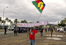 FLNKS (Kanak and Socialist National Liberation Front) members hold "No to Bougival" banners in a Nouméa protest