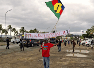 FLNKS (Kanak and Socialist National Liberation Front) members hold "No to Bougival" banners in a Nouméa protest