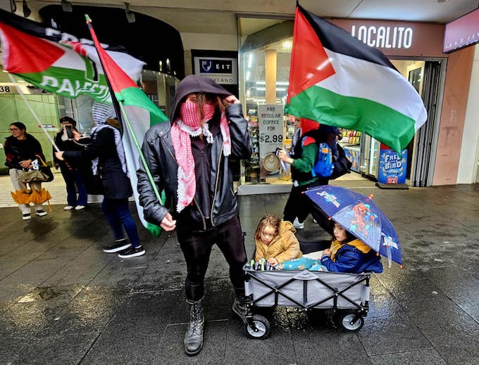 A family rugged up against the rain and cold expressing their disappointment with New Zealand's "weak" policy over the Gaza genocide 