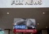 Protesters hold aloft an image of a baby dying from starvation outside the Washington headquarters of Fox News