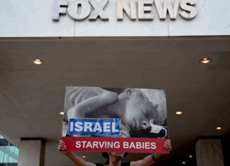 Protesters hold aloft an image of a baby dying from starvation outside the Washington headquarters of Fox News