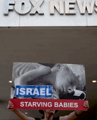Protesters hold aloft an image of a baby dying from starvation outside the Washington headquarters of Fox News