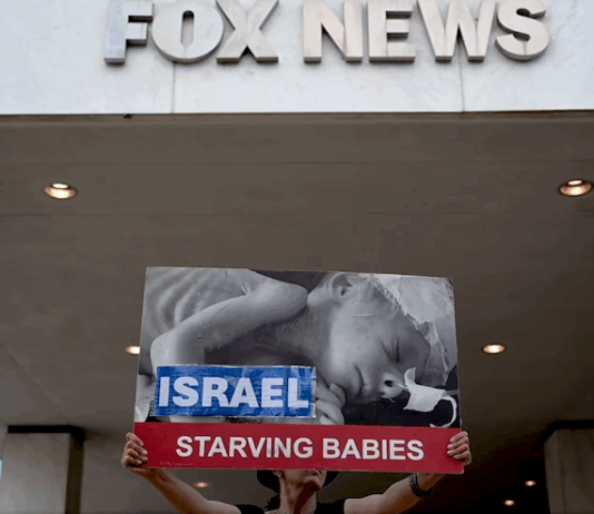 Protesters hold aloft an image of a baby dying from starvation outside the Washington headquarters of Fox News