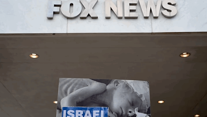 As protesters condemn Western media ‘complicity’, Gaza journalists struggle for survival Protesters hold aloft an image of a baby dying from starvation outside the Washington headquarters of Fox News