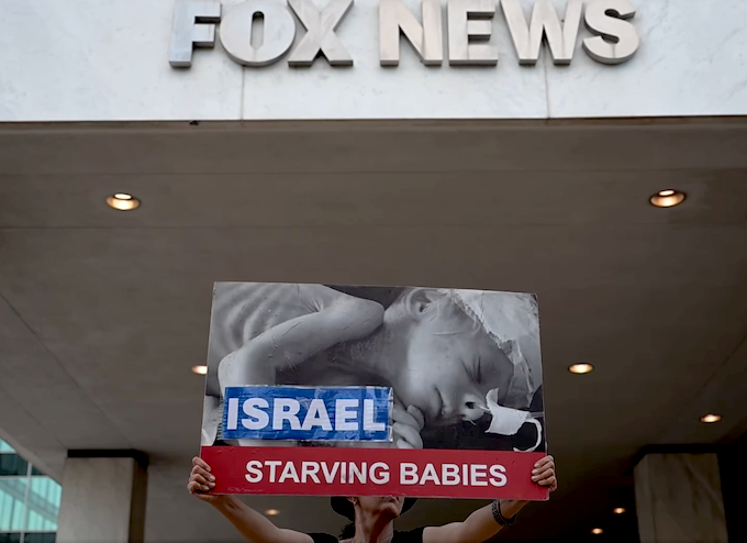 Fox News baby AA 680wide Protesters hold aloft an image of a baby dying from starvation outside the Washington headquarters of Fox News