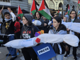 New Zealand pro-Palestine protesters in Auckland carry mock "bodies" today representing Gazan journalists killed by the Israeli military