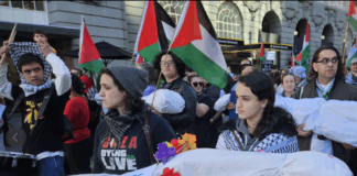 New Zealand pro-Palestine protesters in Auckland carry mock "bodies" today representing Gazan journalists killed by the Israeli military